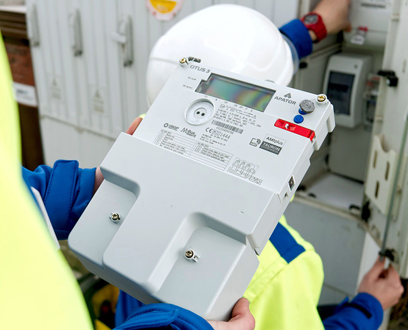 elektromonter trzyma w ręce licznik zdalnego odczytu firmy Apator
